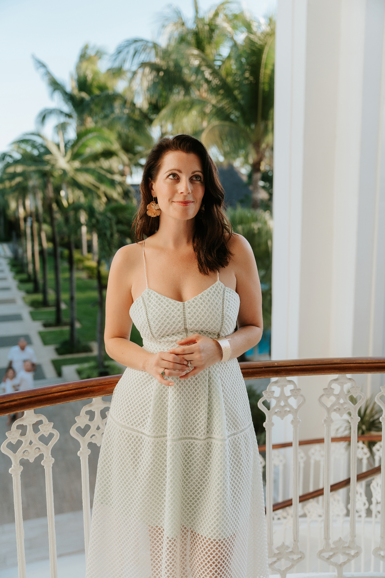 Jennifer Constant standing on a balcony in a white dress