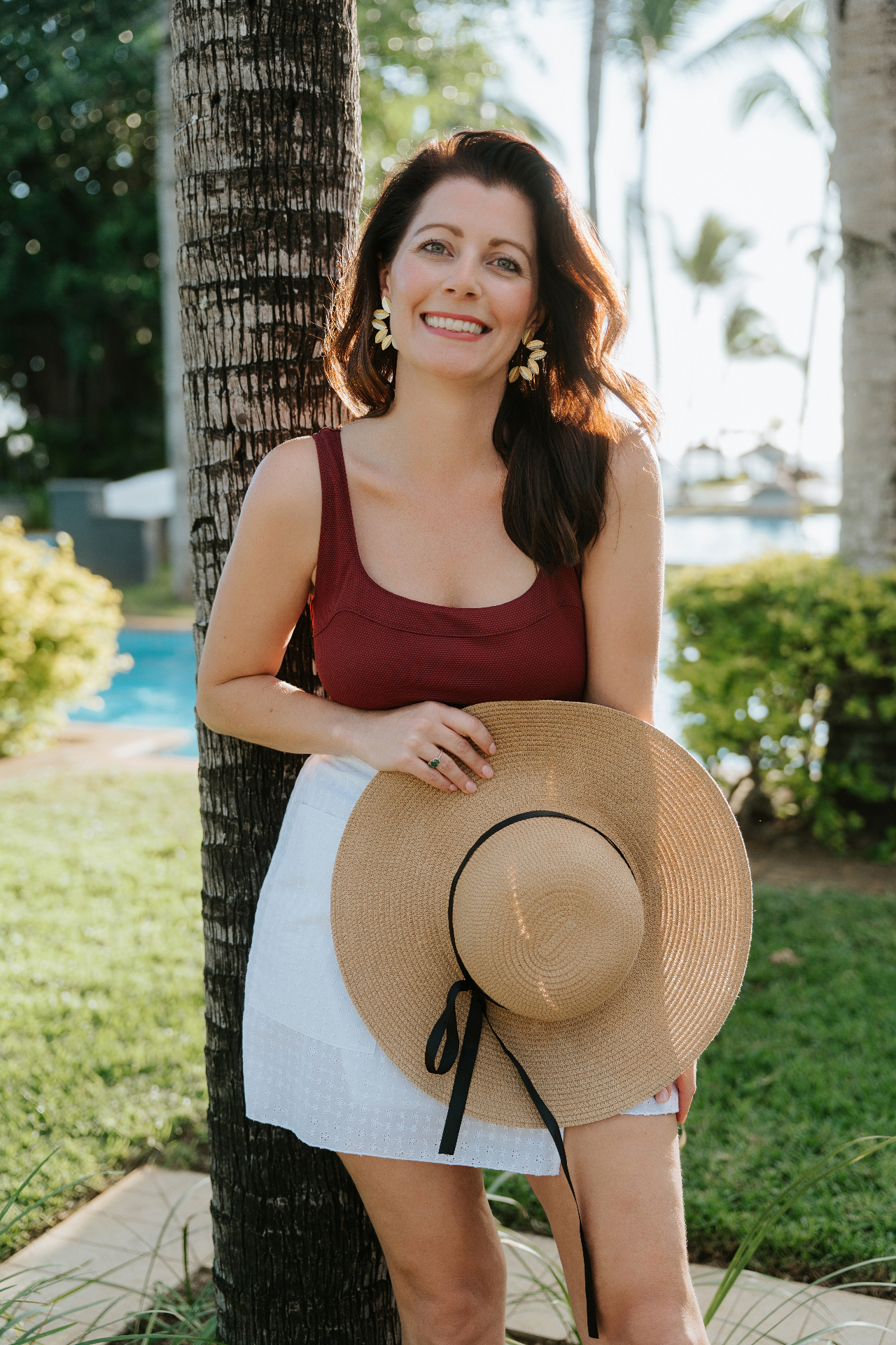 Jennifer Constant smiling outdoors while holding a wide-brim hat